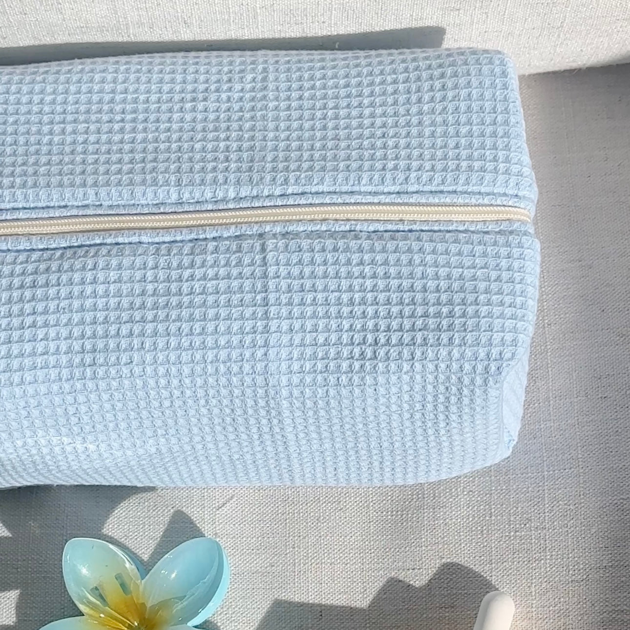 Light blue waffle-knit zip pouch front, zipper closed