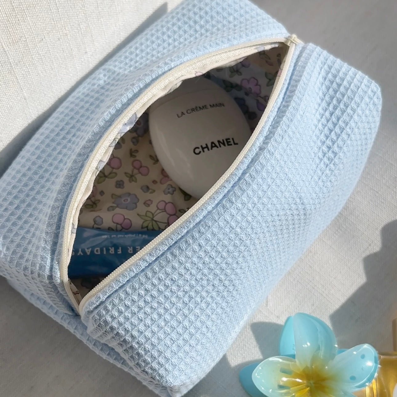 Light blue waffle-knit zip pouch, open top with patterned lining