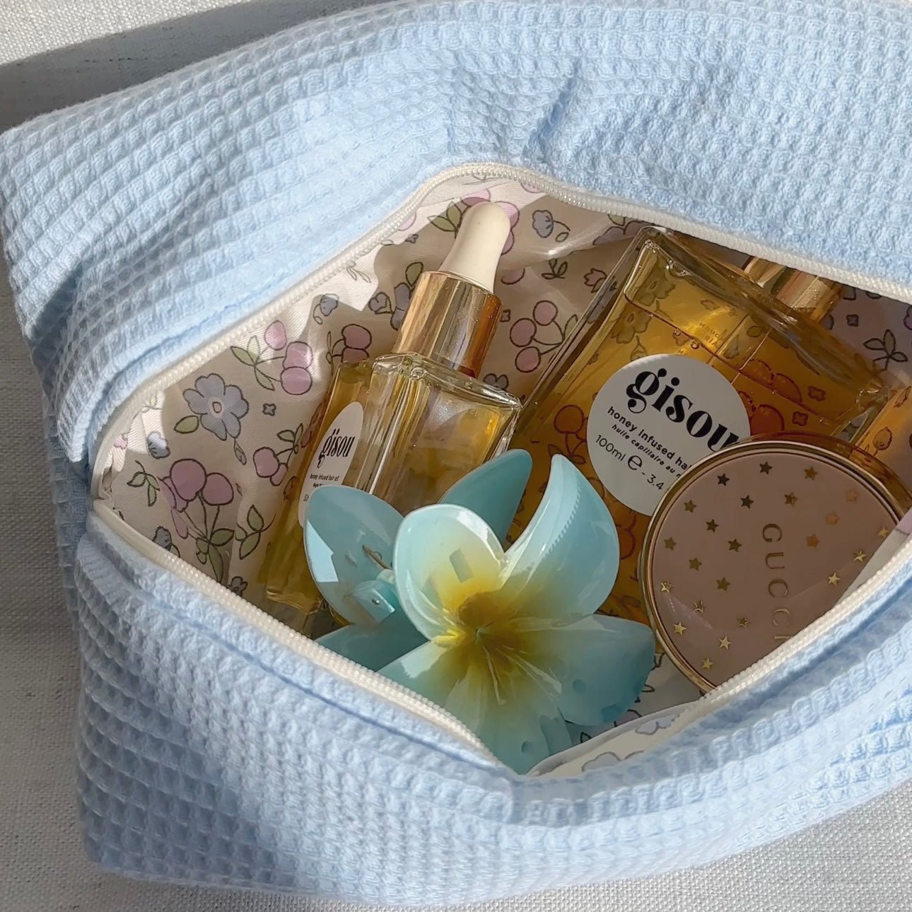 Close view of light blue waffle-knit zip pouch interior with floral lining