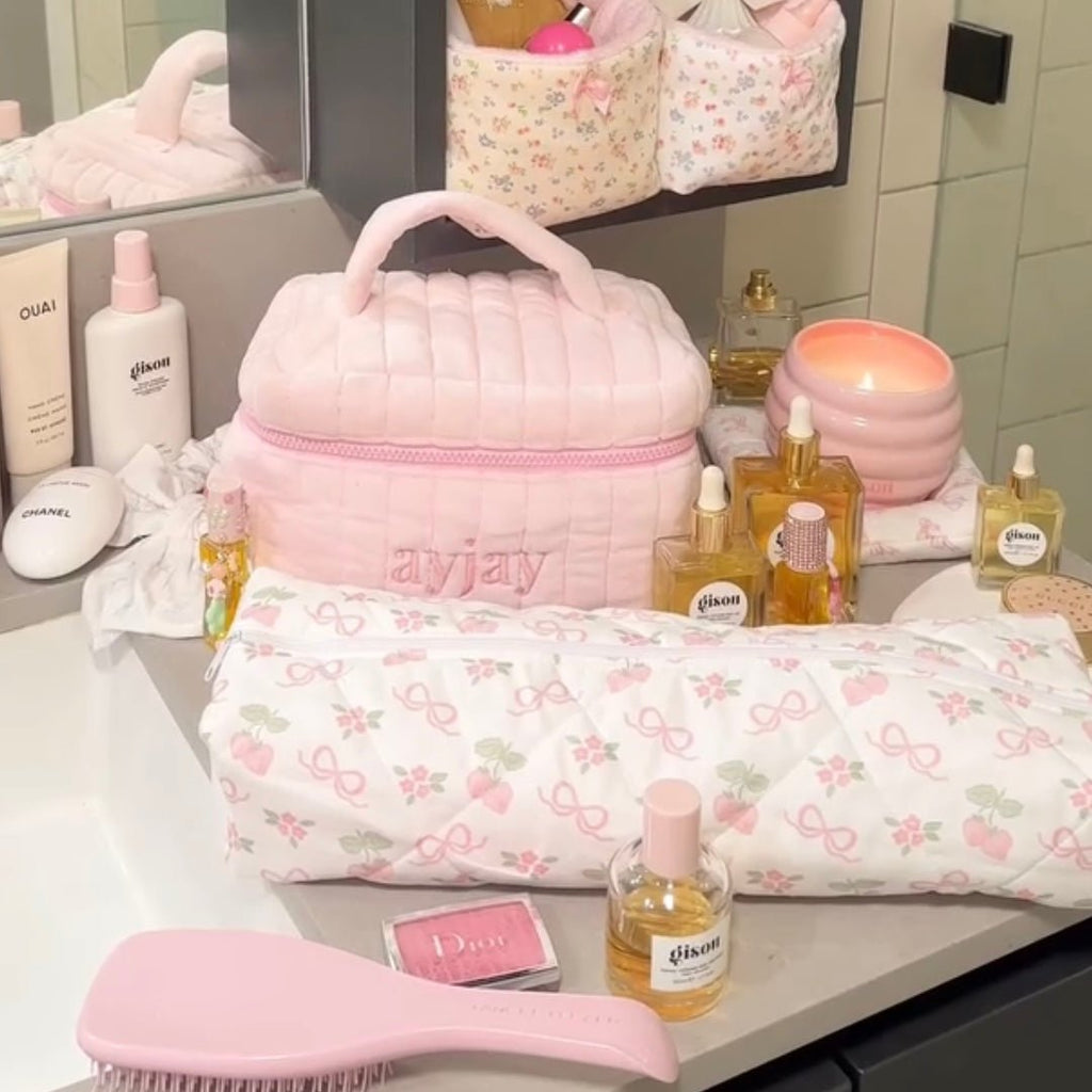 Light pink quilted dome toiletry bag with handle and zippered main pouch