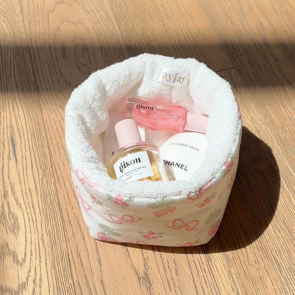 White floral organizer pouch on wood floor, open top with plush pink-lined interior