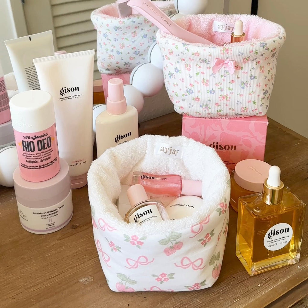 Floral fabric organizer pouch with top handle, pink interior lining, holds beauty bottles