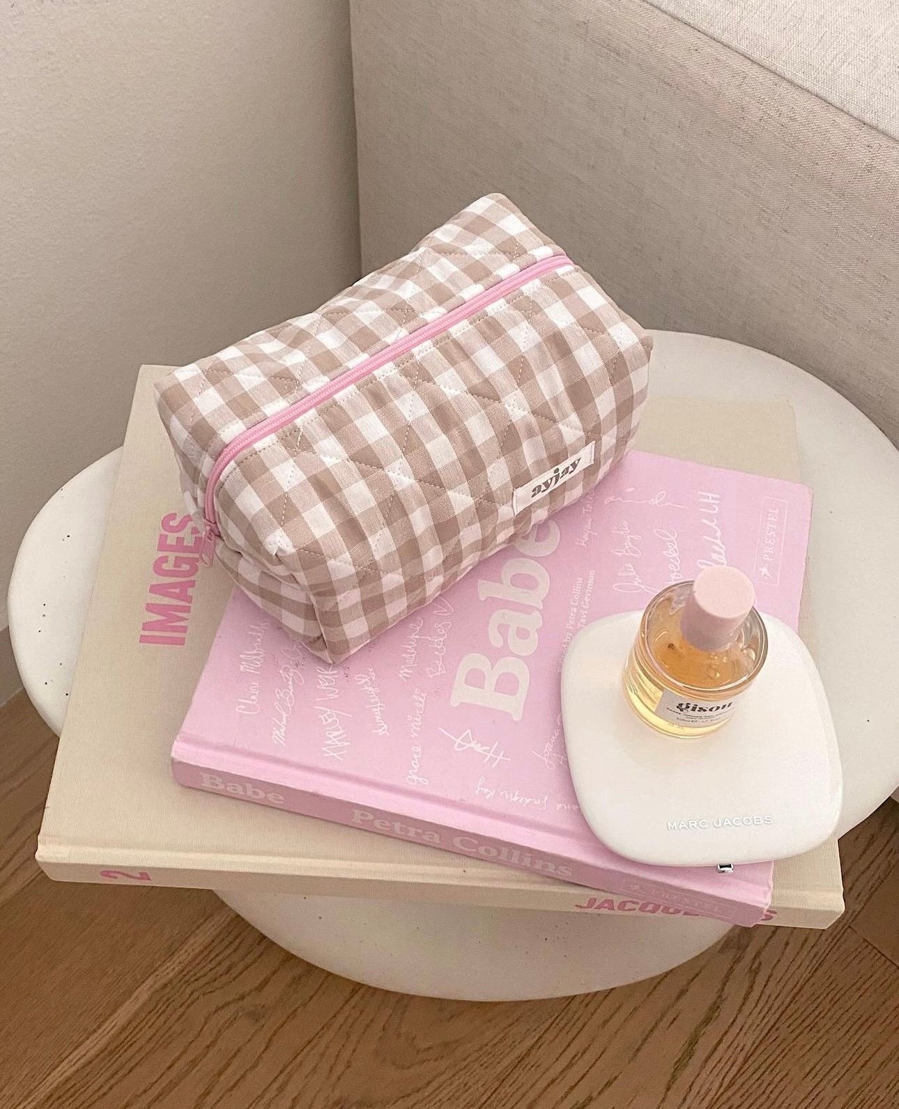 Brown-and-cream gingham pouch with pink zip and small label patch on front