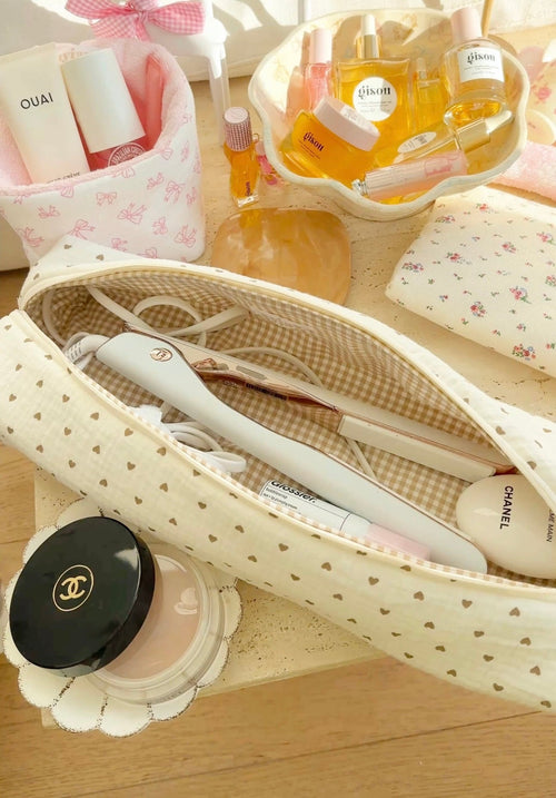 Cream toiletry case with brown-heart pattern, plus gingham-lined section and zipper pocket