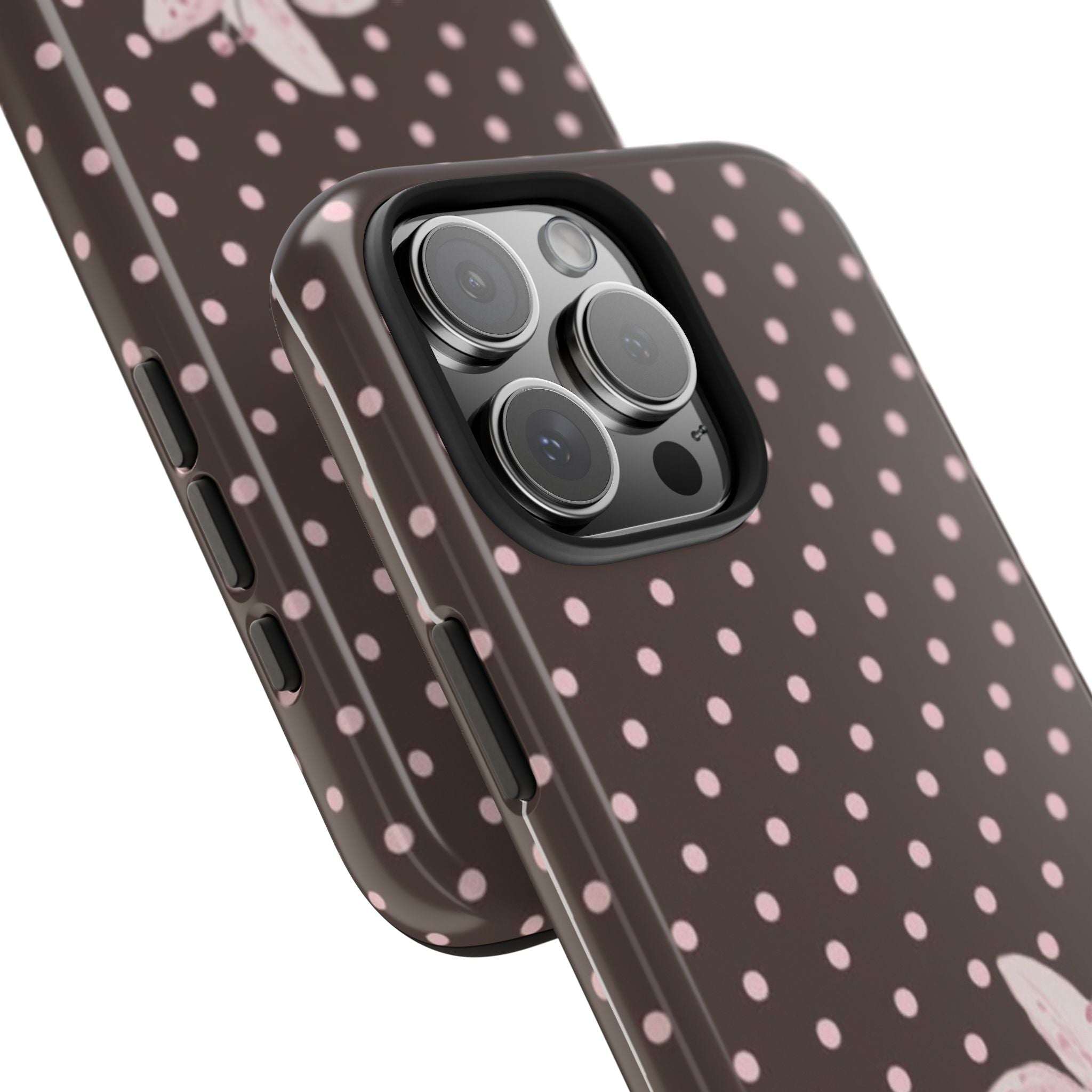 Brown case edge and buttons with pink polka dot pattern; camera lens area visible