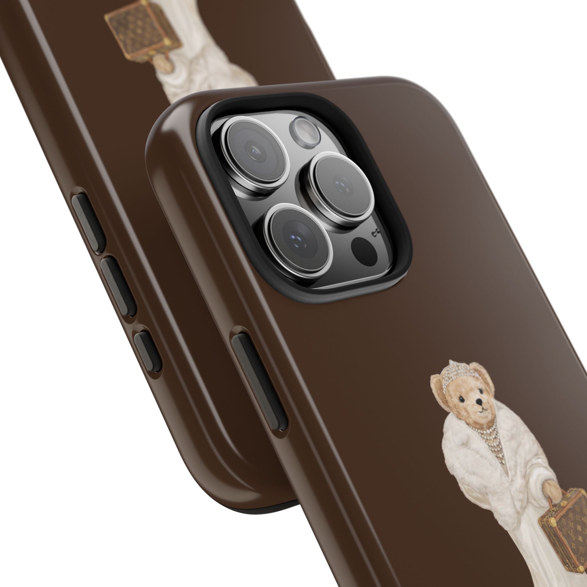 Brown case side view with teddy bear in white robe holding briefcase near camera lenses