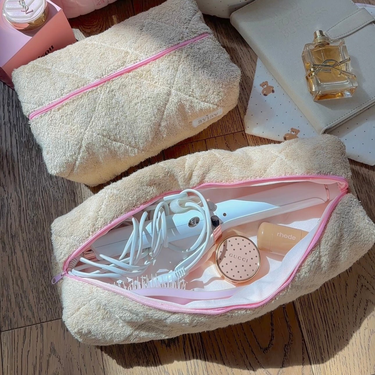 Teddy hair tool pouch with pink trim and zipper, open with white hair styling brush and tool