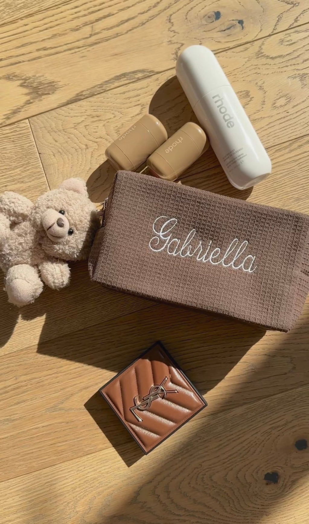 Brown waffle-knit pouch with white cursive name embroidery, zip pouch style