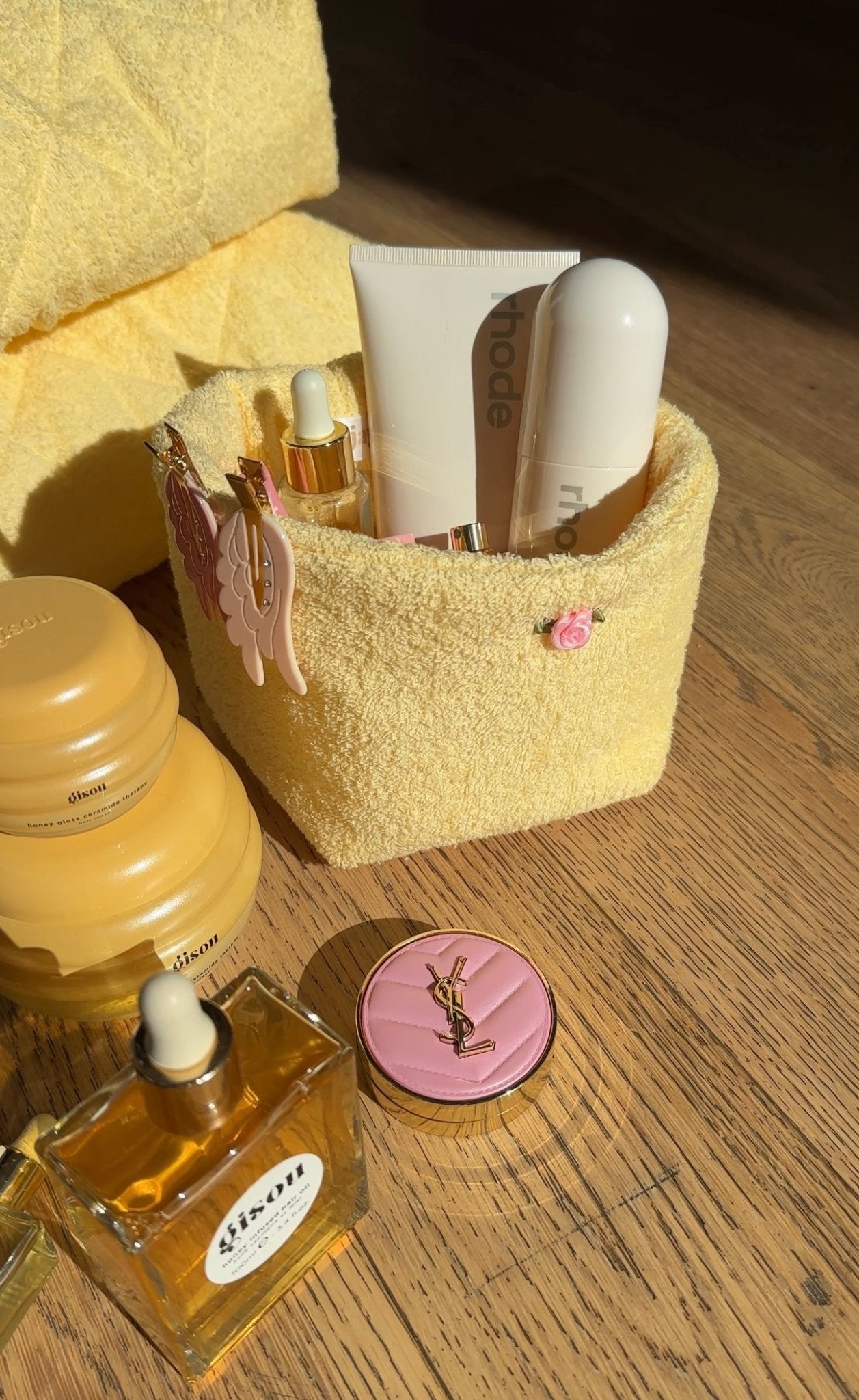 Butter yellow terrycloth organizer with pink bow charm and toiletries inside