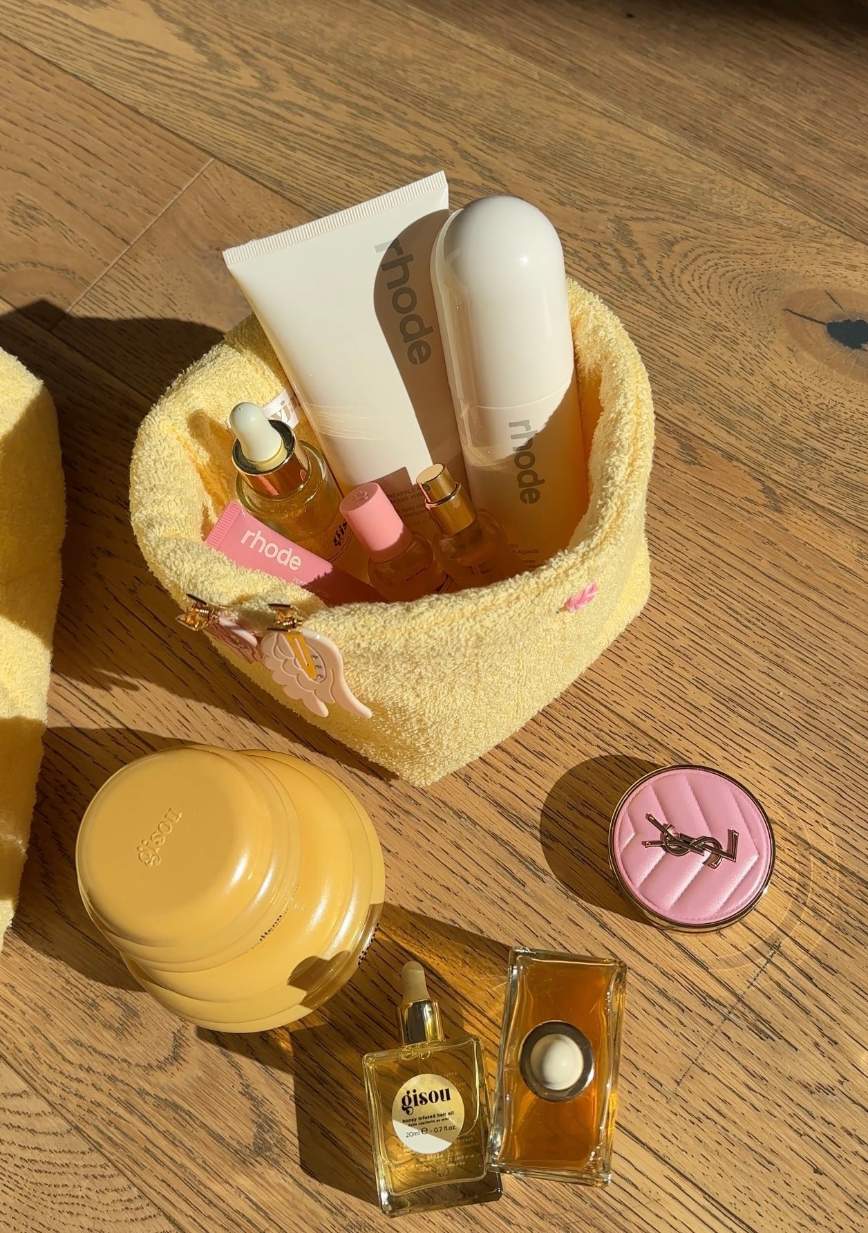 Butter yellow terrycloth organizer basket with pink charm cap and assorted bottles