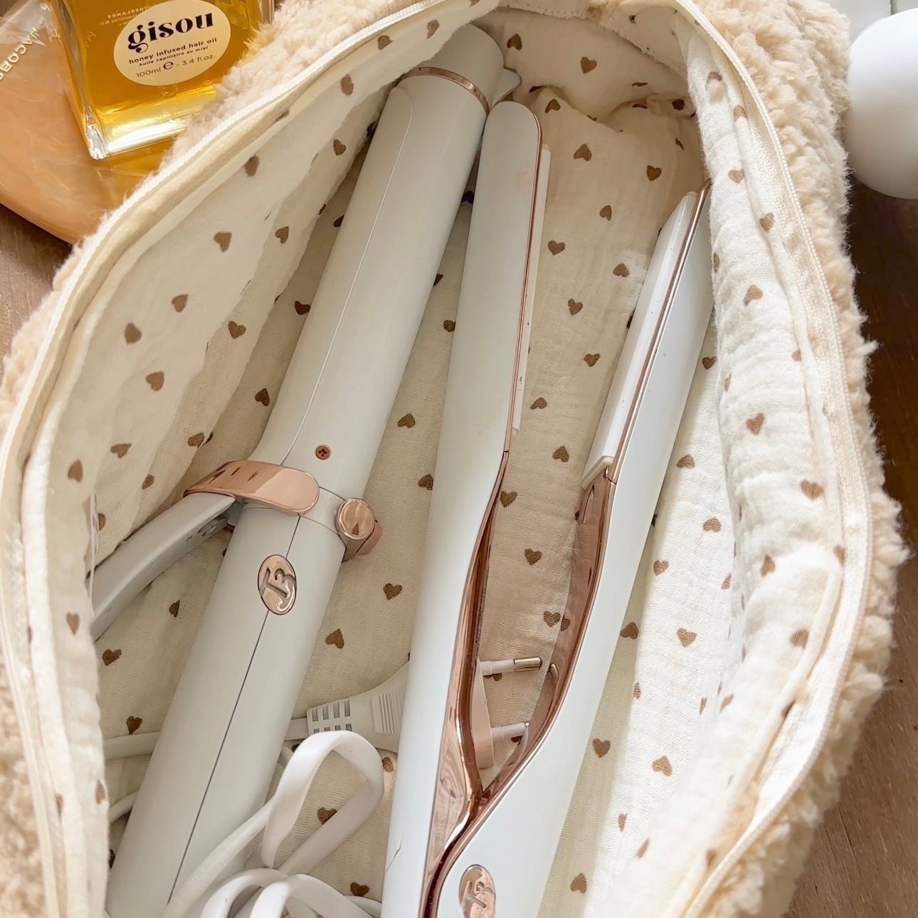 Heart-pattern fabric lining inside a soft teddy pouch, showing organizer compartments