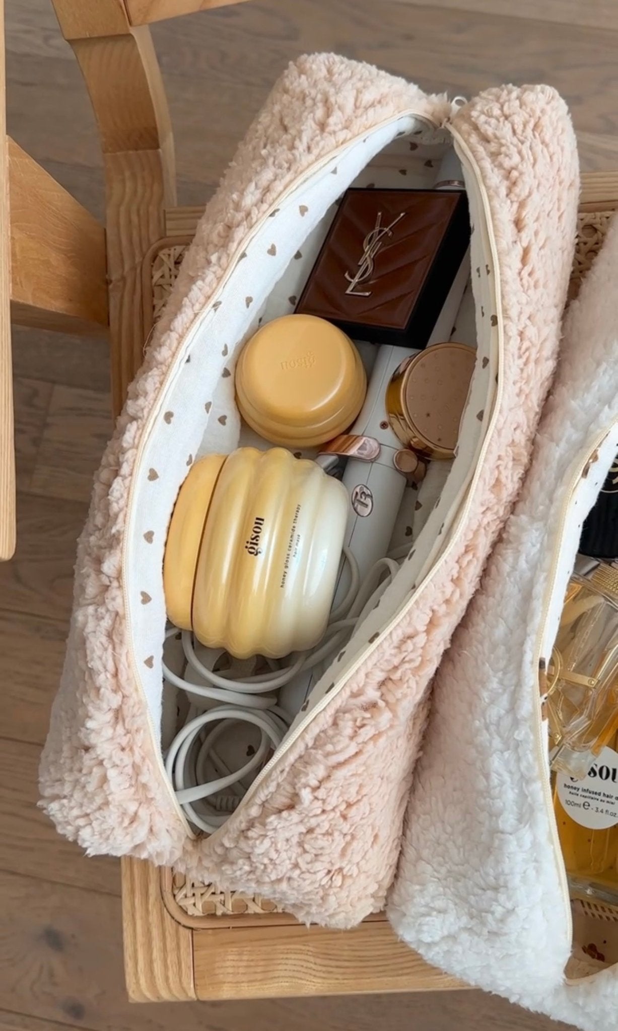 Soft teddy pouch with heart lining, holding hair tools and bottles inside