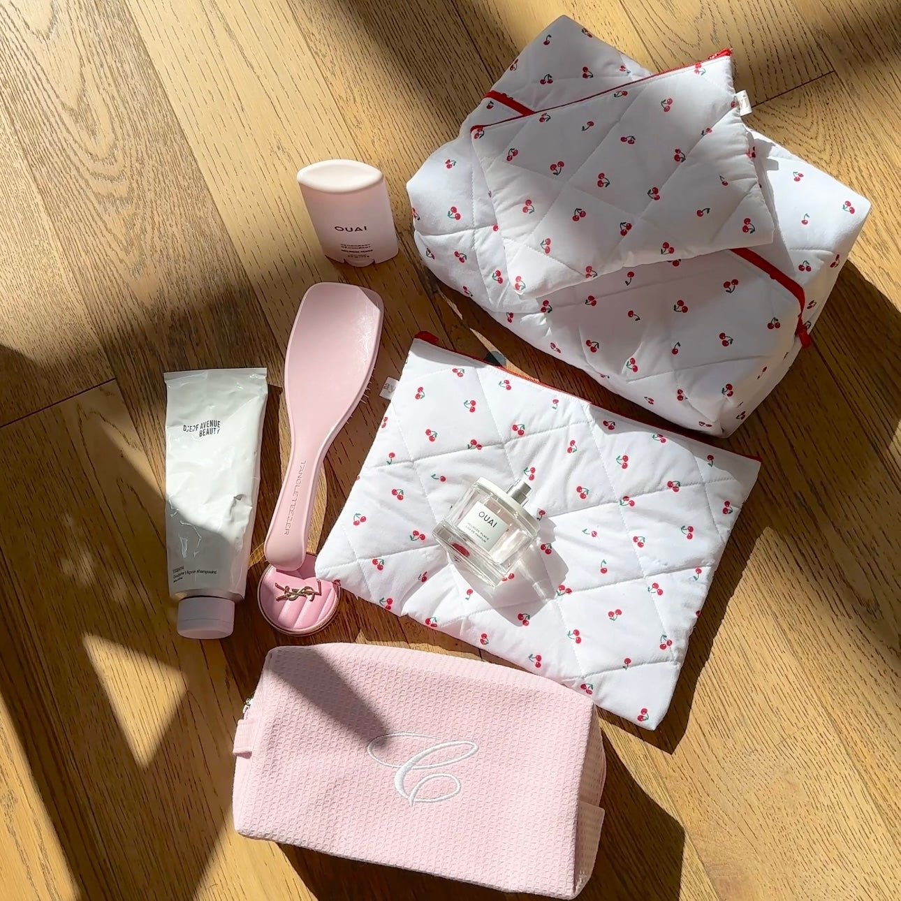 Cherry-pattern quilted pouch set with red trim, plus pink pouch and hair care items