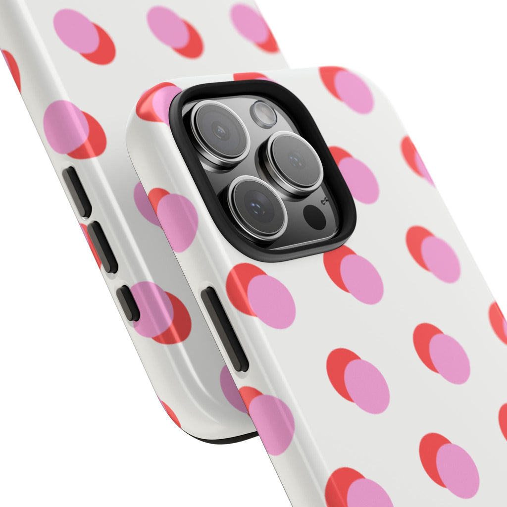 Close-up of white phone case with pink/red polka dots and camera lens openings