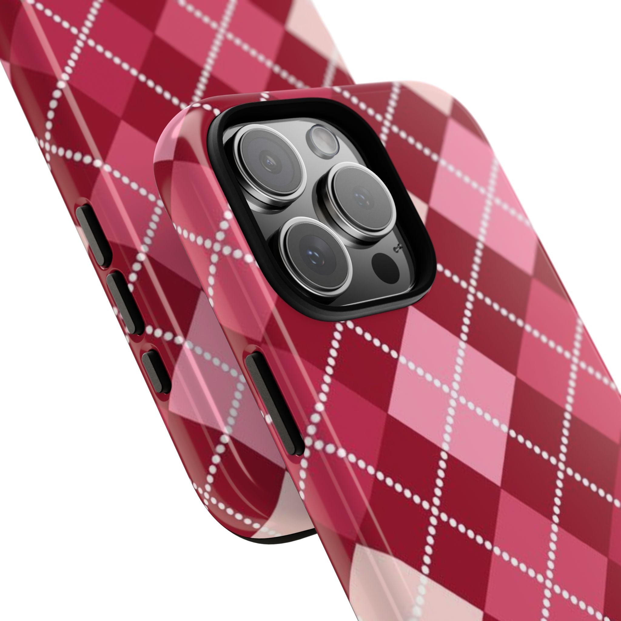 Angled view of red and pink argyle phone case with white dotted diamonds and side buttons
