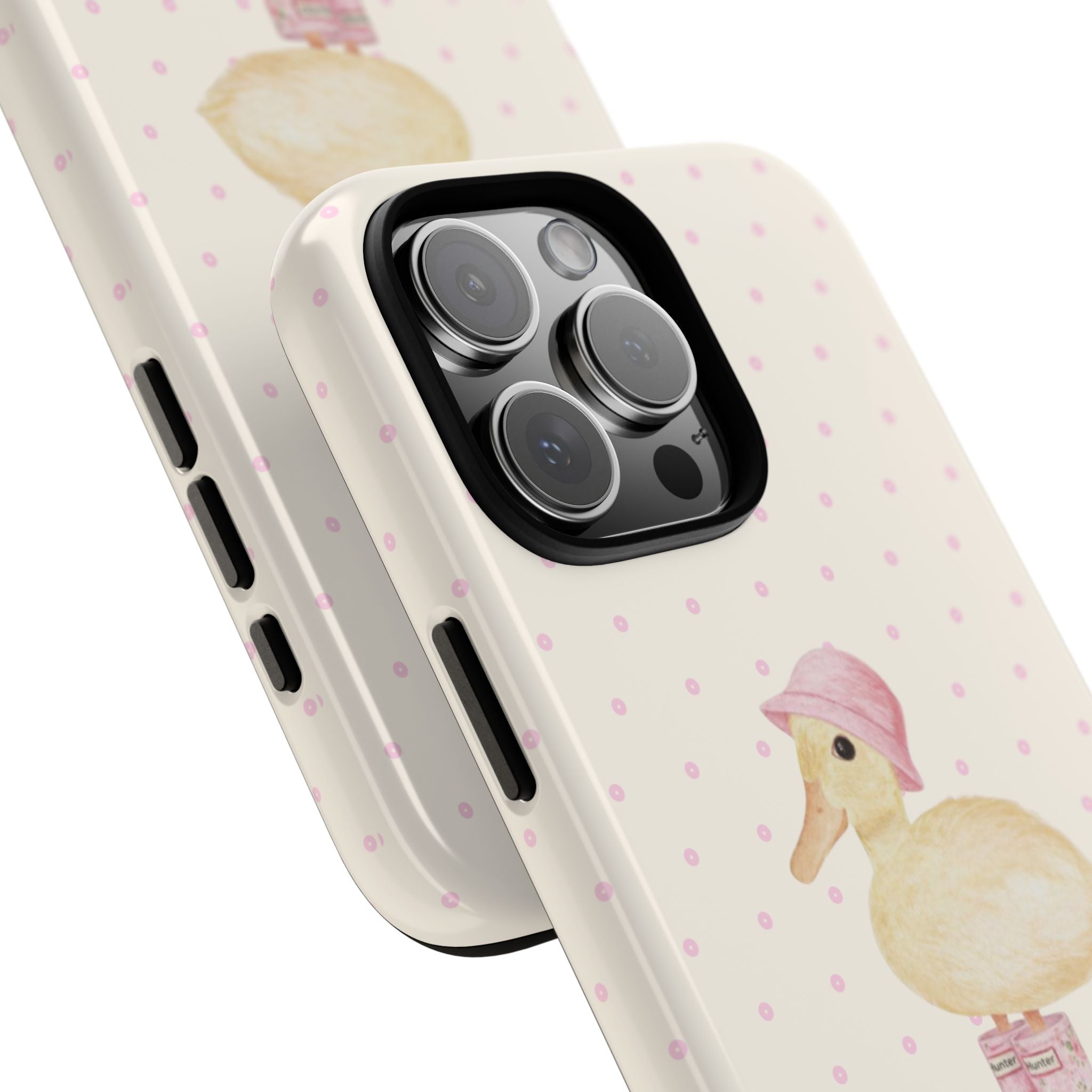 Close-up cream phone case with duck graphic, pink dots, side button cutouts