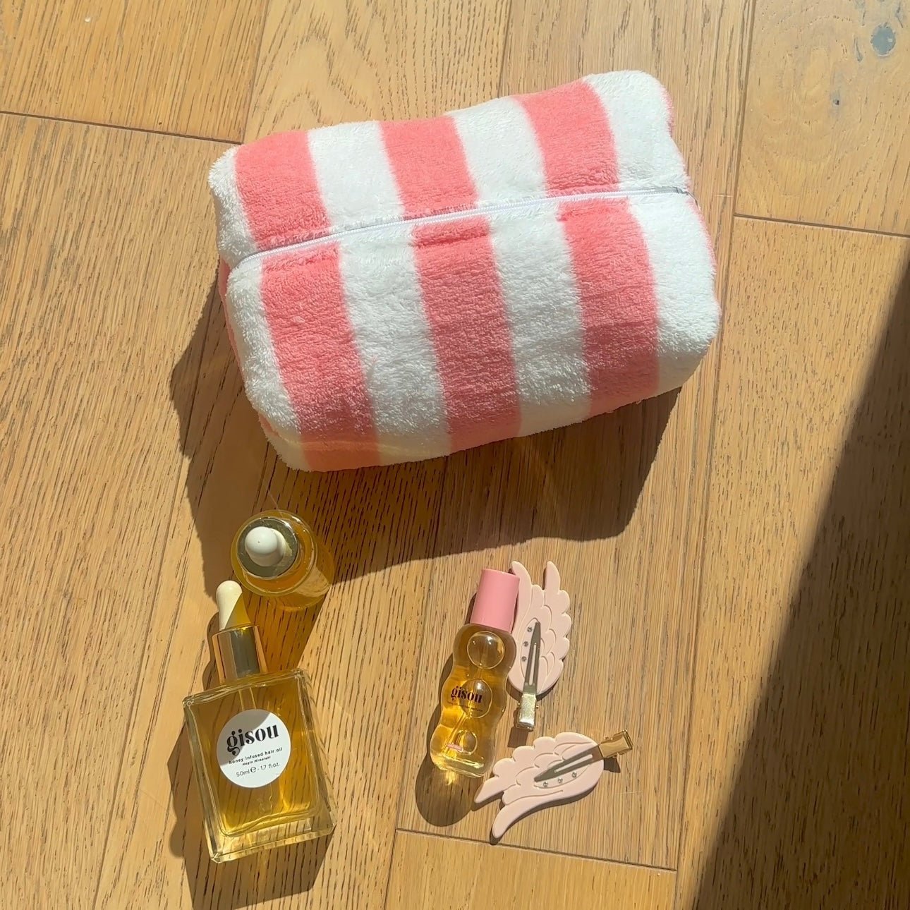 Coral and white striped plush zip pouch with animal charm at the side
