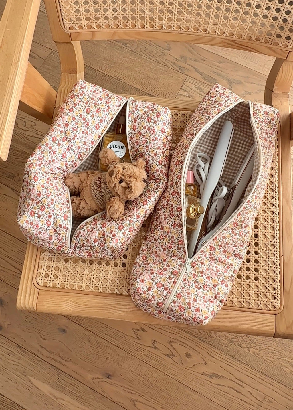 Two white floral zip pouches, one open with toiletries; lined interior visible
