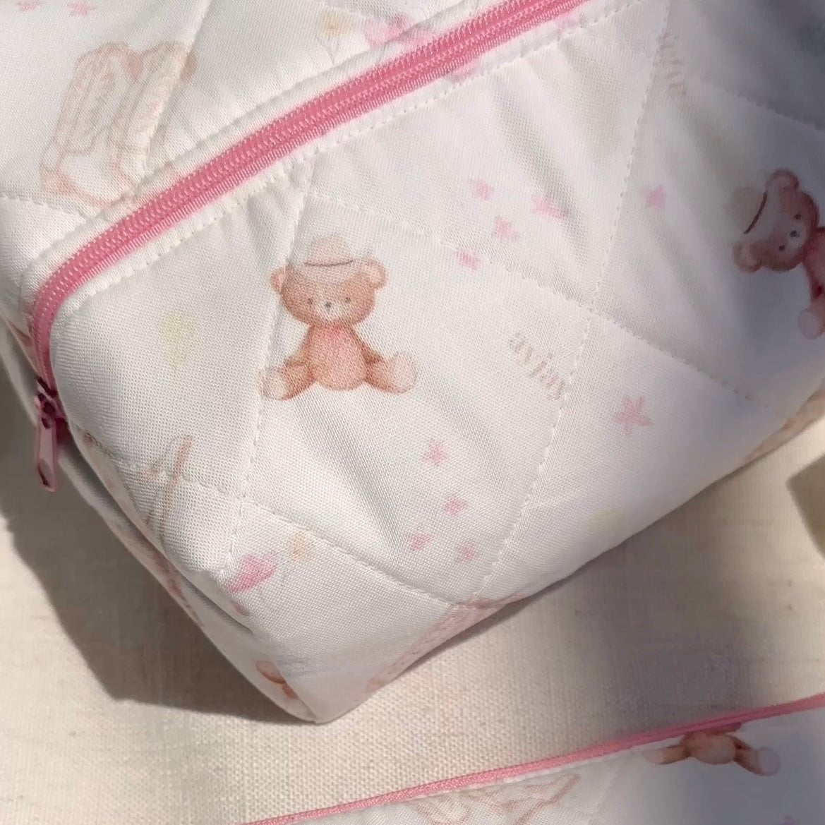 White quilted pouch corner with teddy bear print and pink zipper