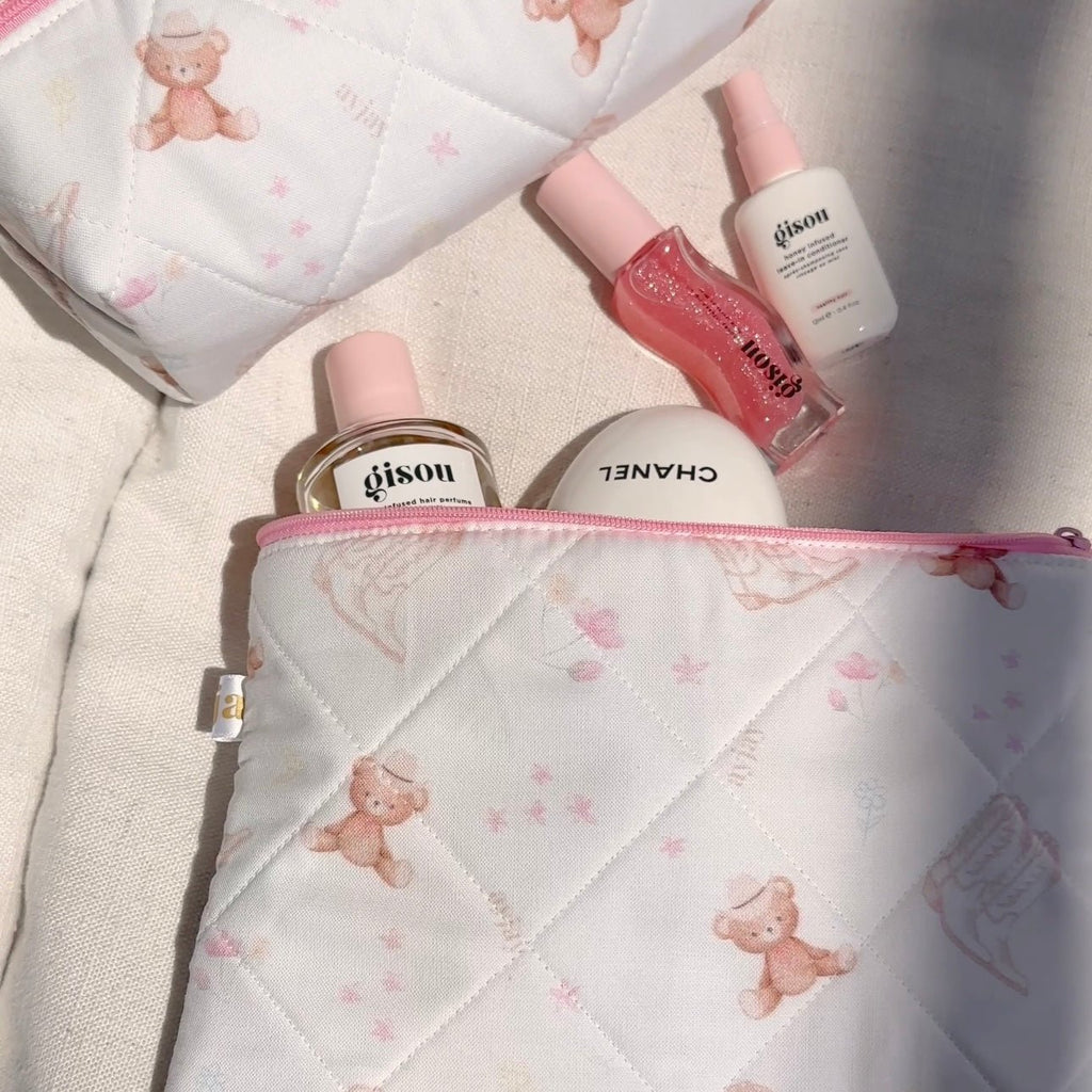 Close-up quilted white pouch with teddy bear print and pink zip