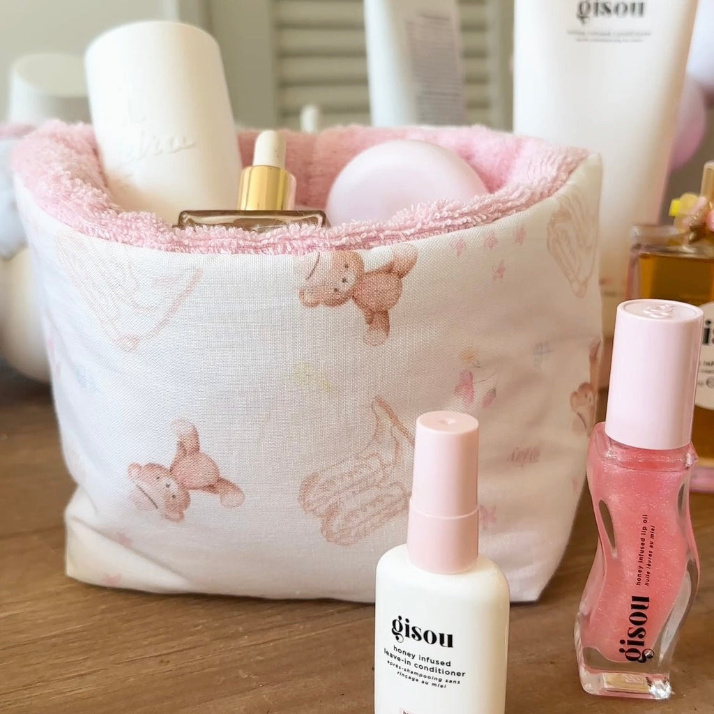 Close-up of teddy bear boots organizer: pink rim, printed fabric with items inside