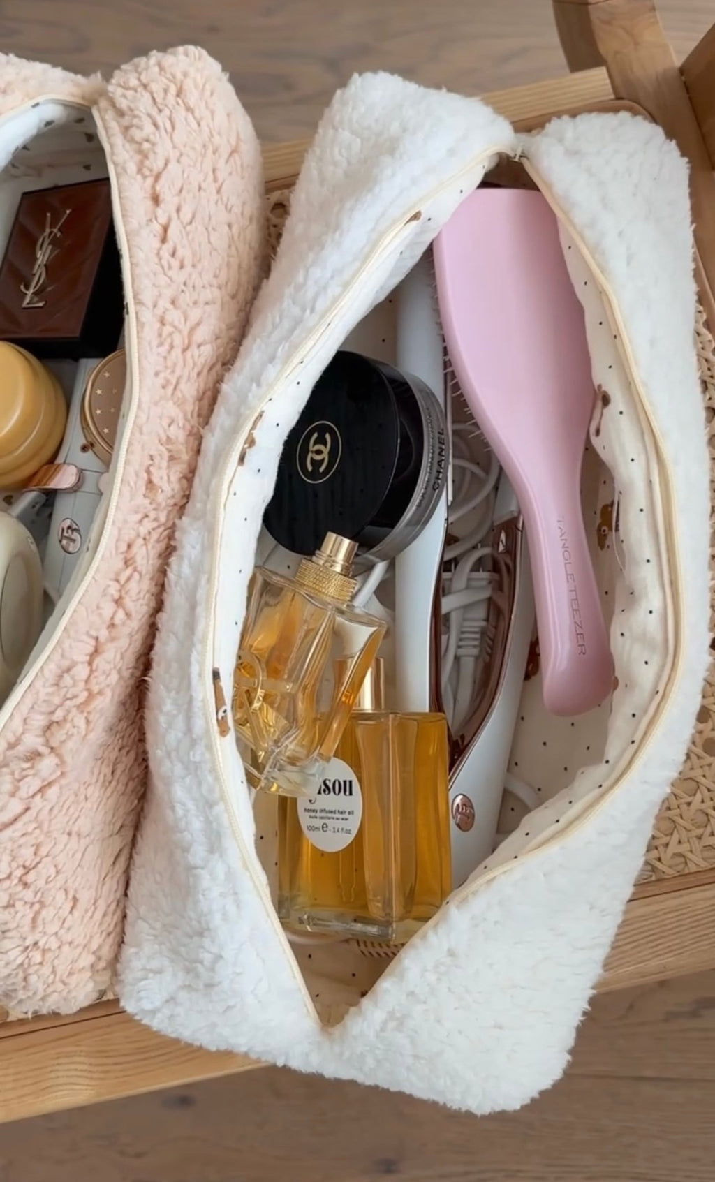 Two plush teddy pouches with zip openings, cream and blush tones, open compartments