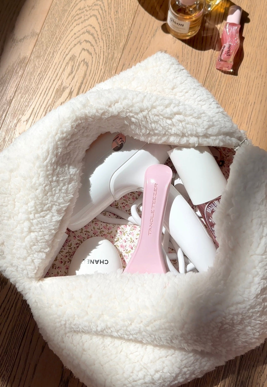 Cream teddy pouch open with pink floral lining and inner compartments visible