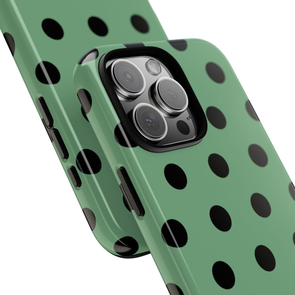 Close-up emerald green phone case with black polka dots around the camera lenses