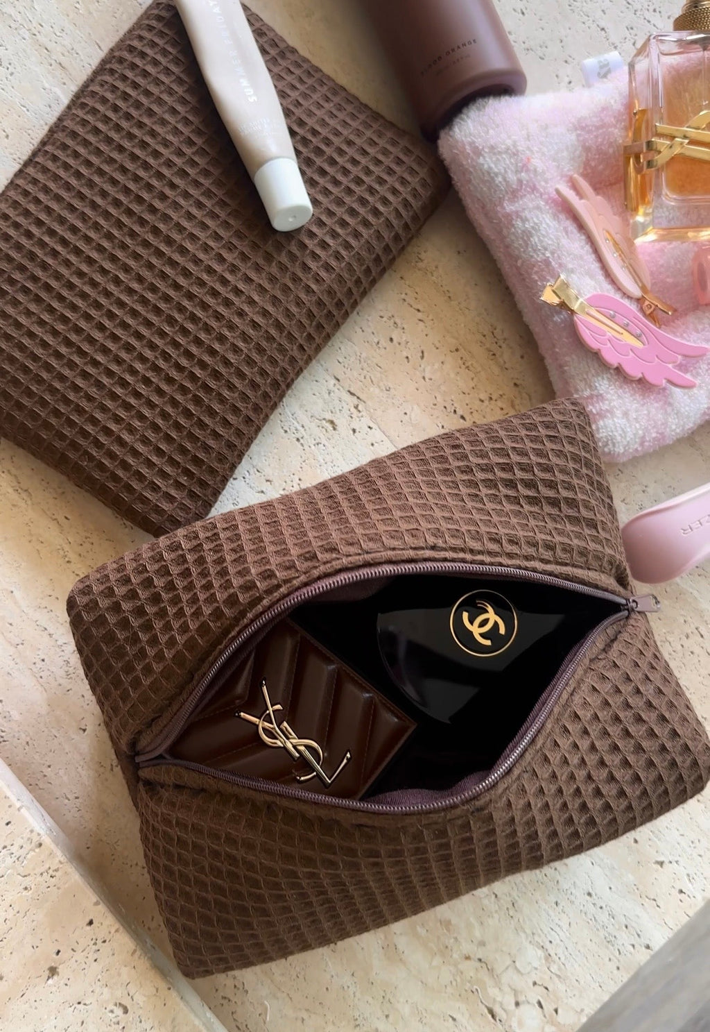 Espresso brown waffle knit zip pouch, open with black lining and gold zipper pull