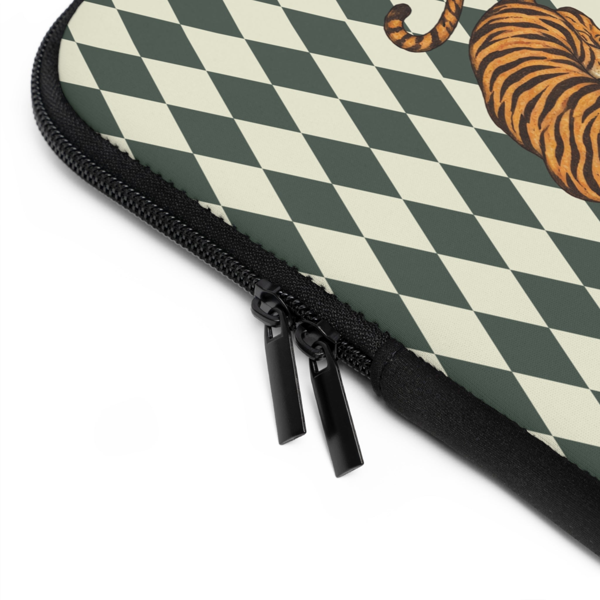 Corner close-up: green diamond check neoprene sleeve with black zipper pulls