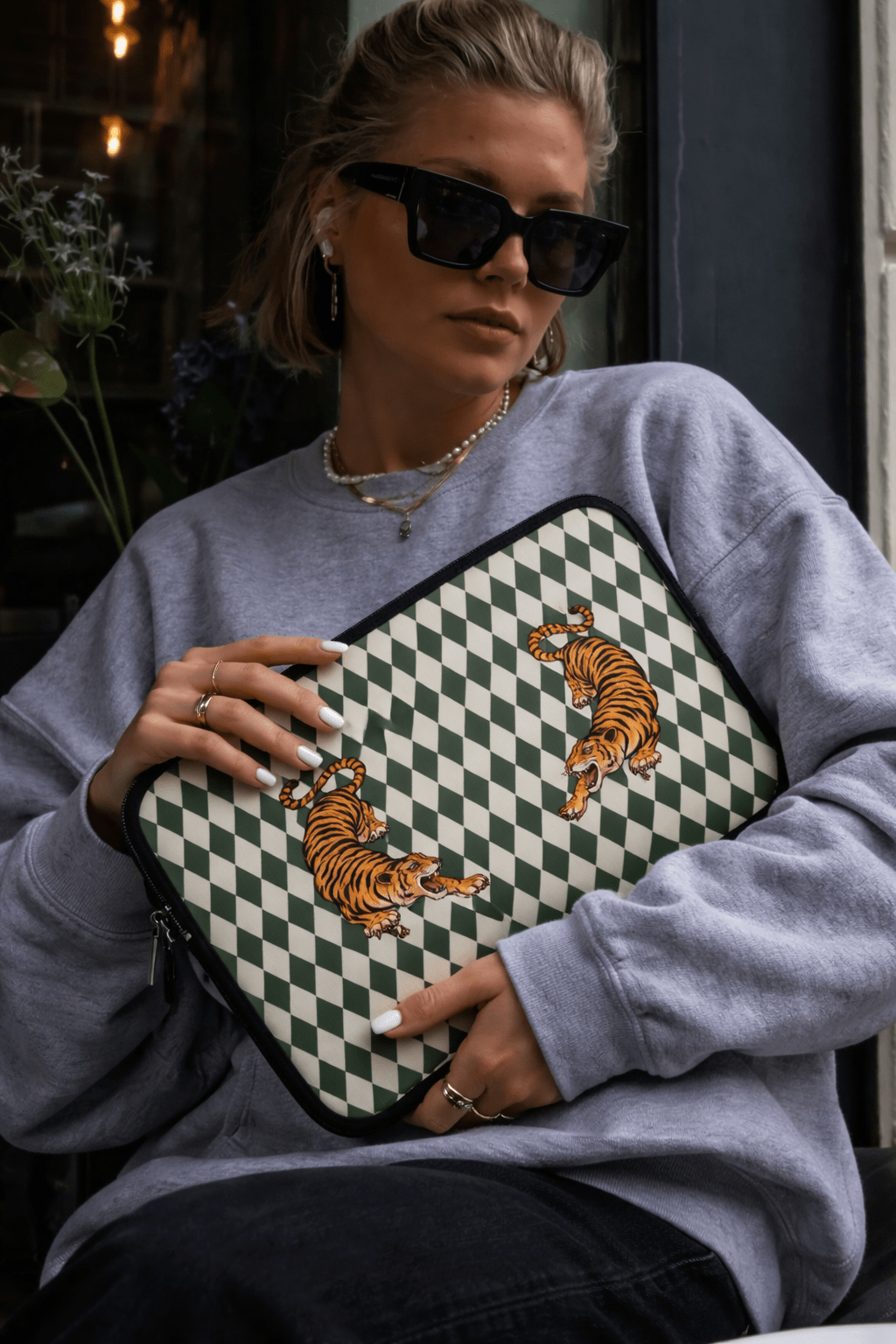 Green diamond checker neoprene sleeve with tiger print, black zipper edge