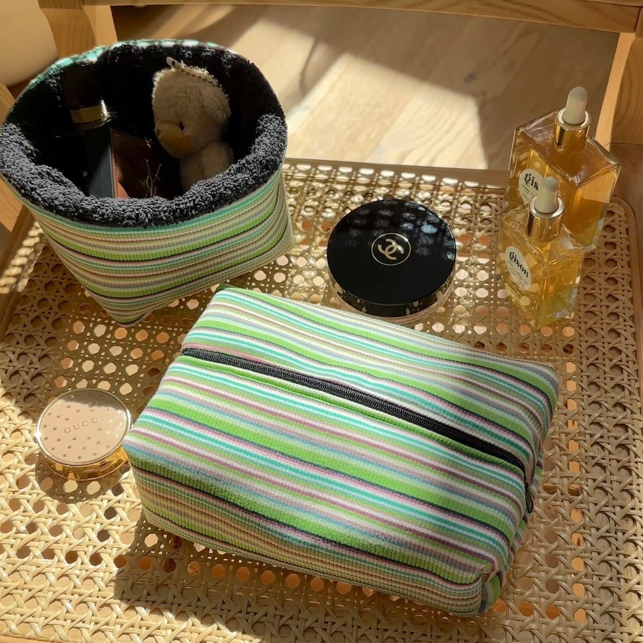 Green striped zip pouch, front view with black trim and rounded corners