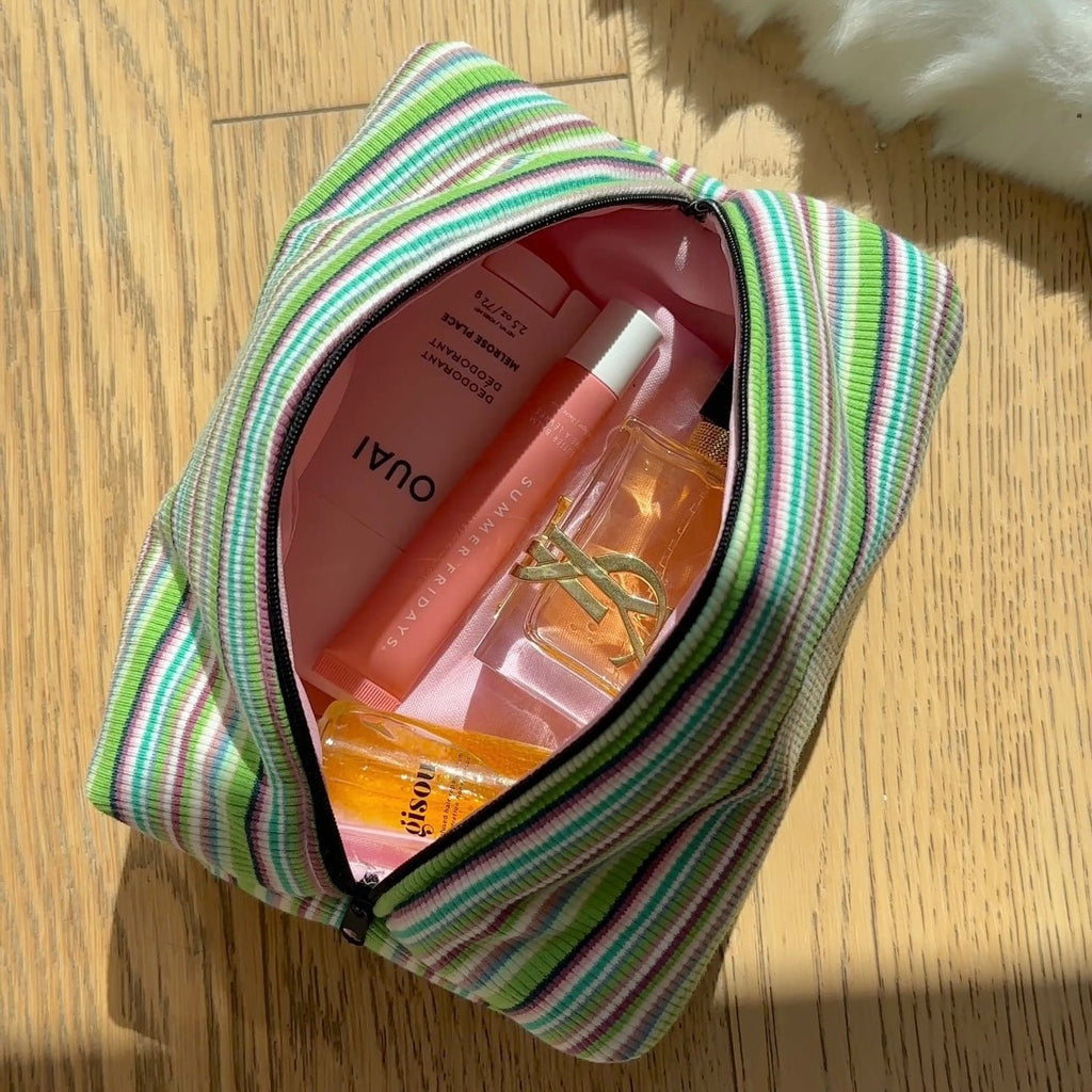 Green striped zippered pouch, open top showing interior lining and divider