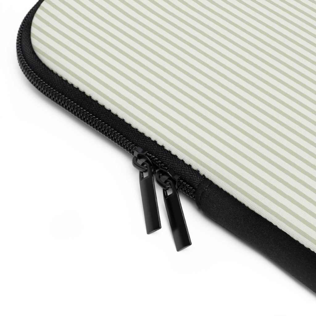 Close-up: green striped neoprene sleeve edge with black zipper pull and stitched border