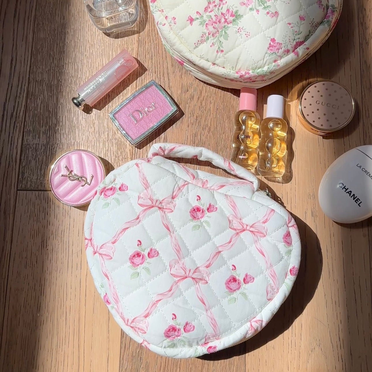 Heart-shaped quilted bag with pink floral bows on a light background