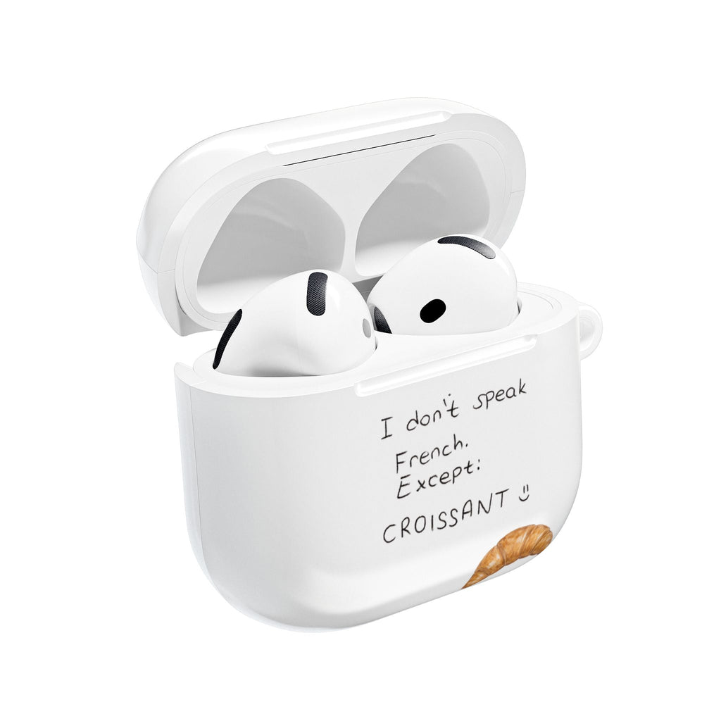 White AirPods case, open lid with cartoon earbuds; “I don’t speak French” text + croissant