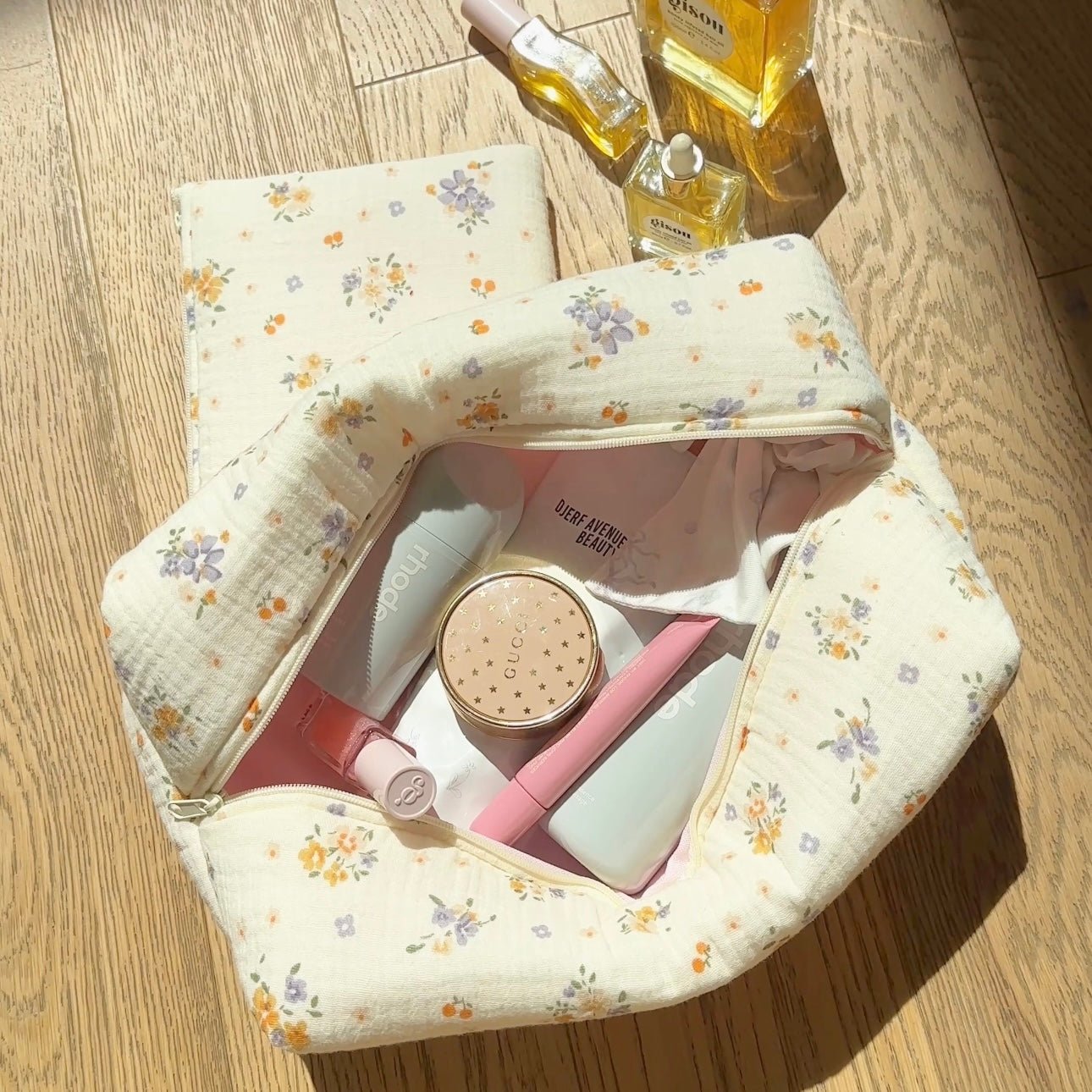 Large ivory floral zippered pouch open, pink-lined interior with compartments