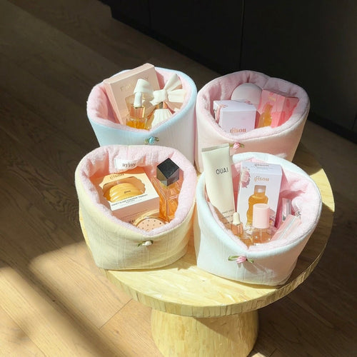 Pastel fabric organizer basket set on table with rounded openings for toiletries