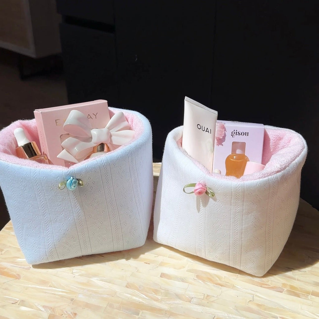 Baby blue jacquard lace knit organizer bin with ribbon bow handle, holding small bottles