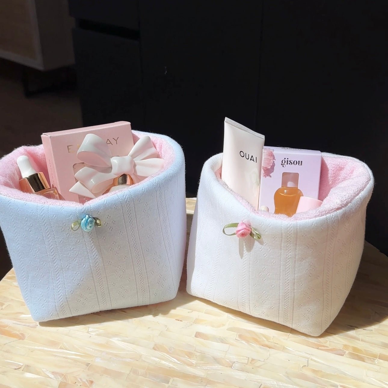 Baby blue jacquard lace knit organizer bin with ribbon bow handle, holding small bottles