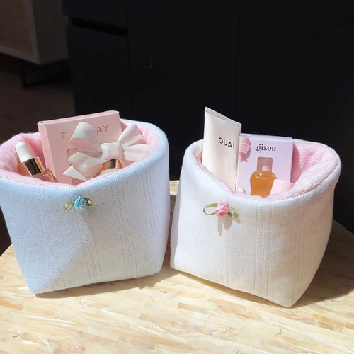 Baby blue jacquard lace knit organizer bin with ribbon bow handle, holding small bottles