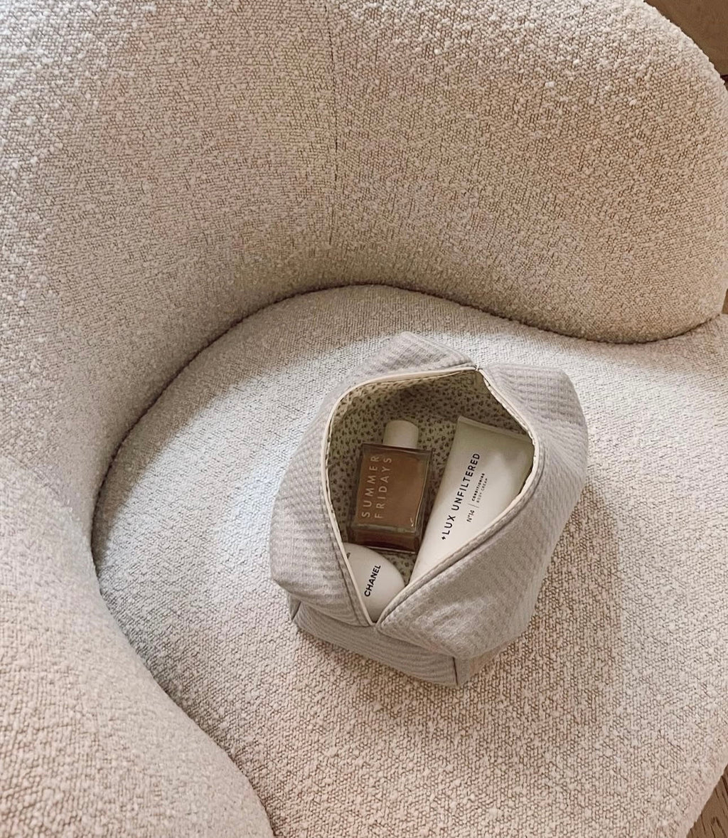 Cream-white waffle knit zip pouch, visible inner pocket lining.