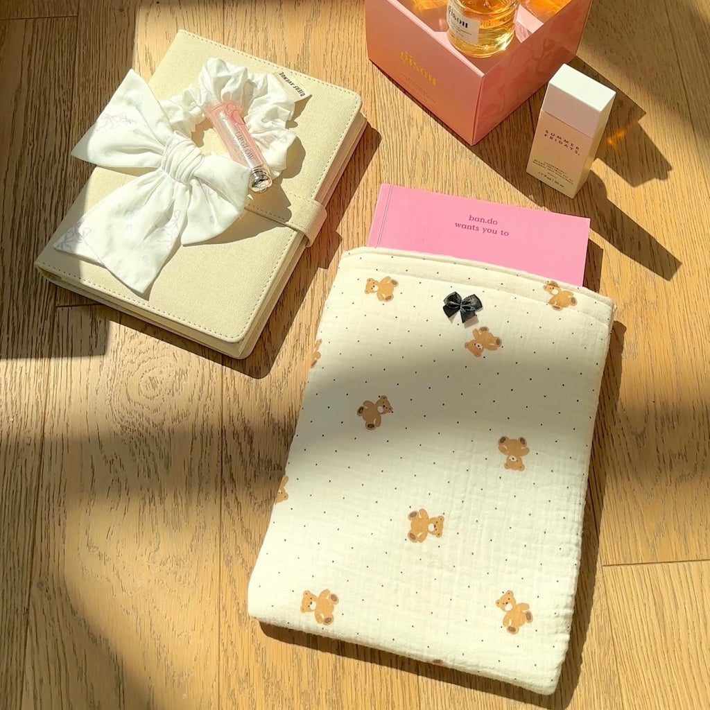 Cream Kindle book sleeve with scattered teddy bear print and bow closure tab