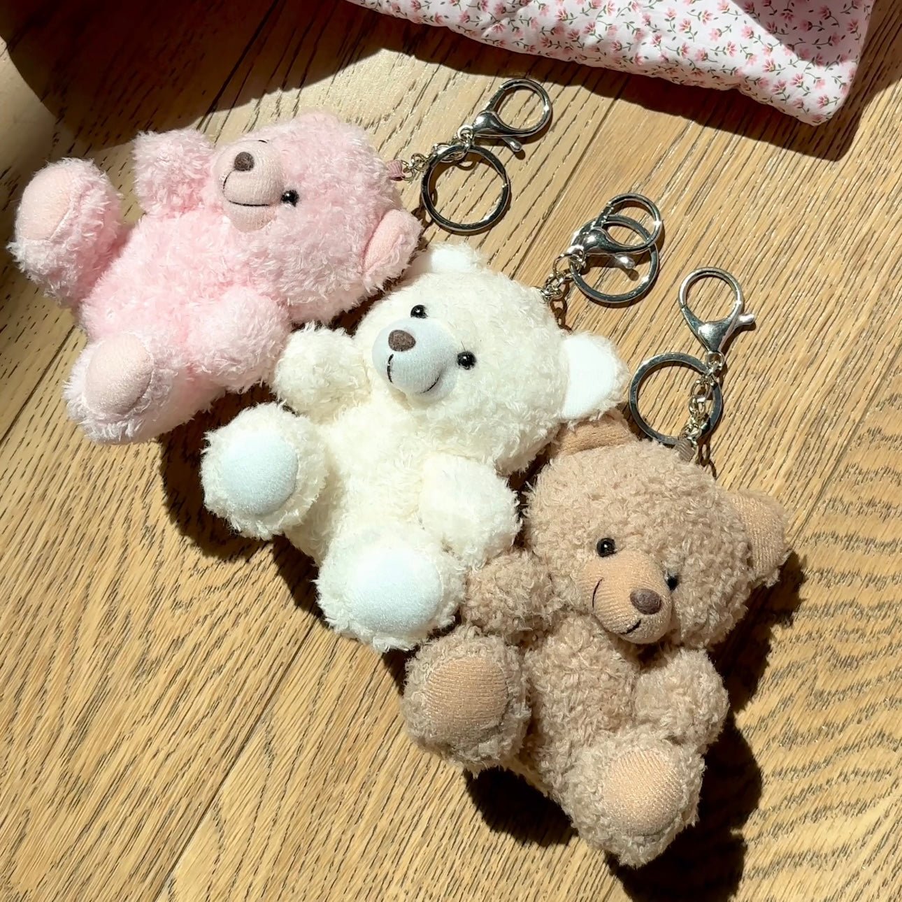 Pink, white, and tan teddy bear plush keychain charms with silver split rings
