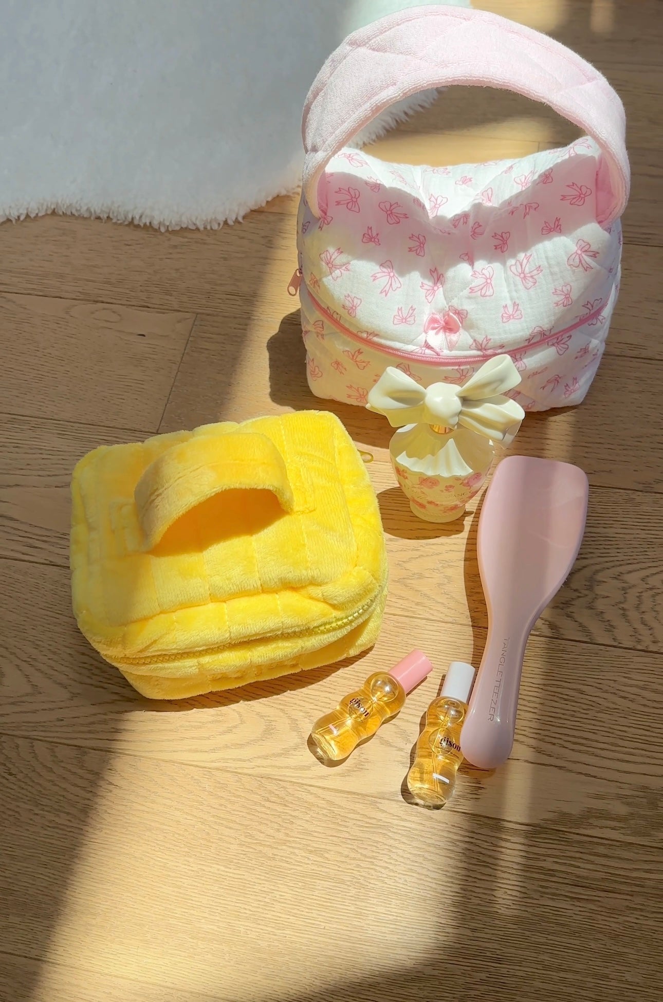 Yellow mini vanity bag with bow detail and butterfly print lining on wooden floor