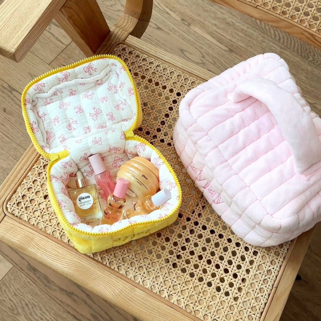 Open yellow mini vanity bag with pink bows print lining and zipper-trim edging