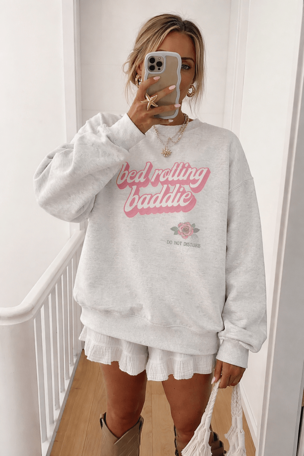Light gray crewneck sweatshirt, pink 'bed rotting baddie' text graphic with rose