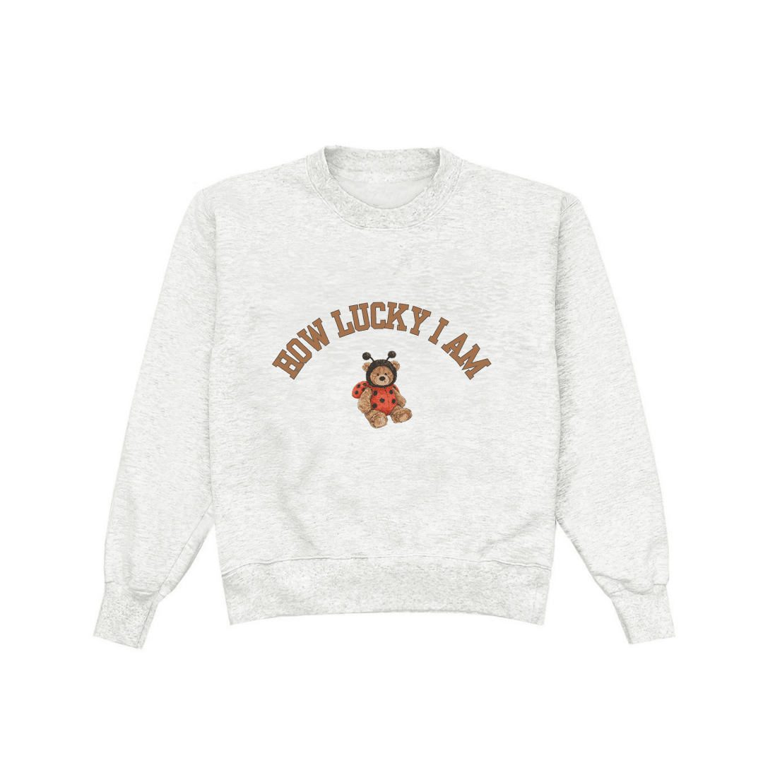 Light gray crewneck sweatshirt front view with bear-and-ladybug 'HOW LUCKY I AM' print