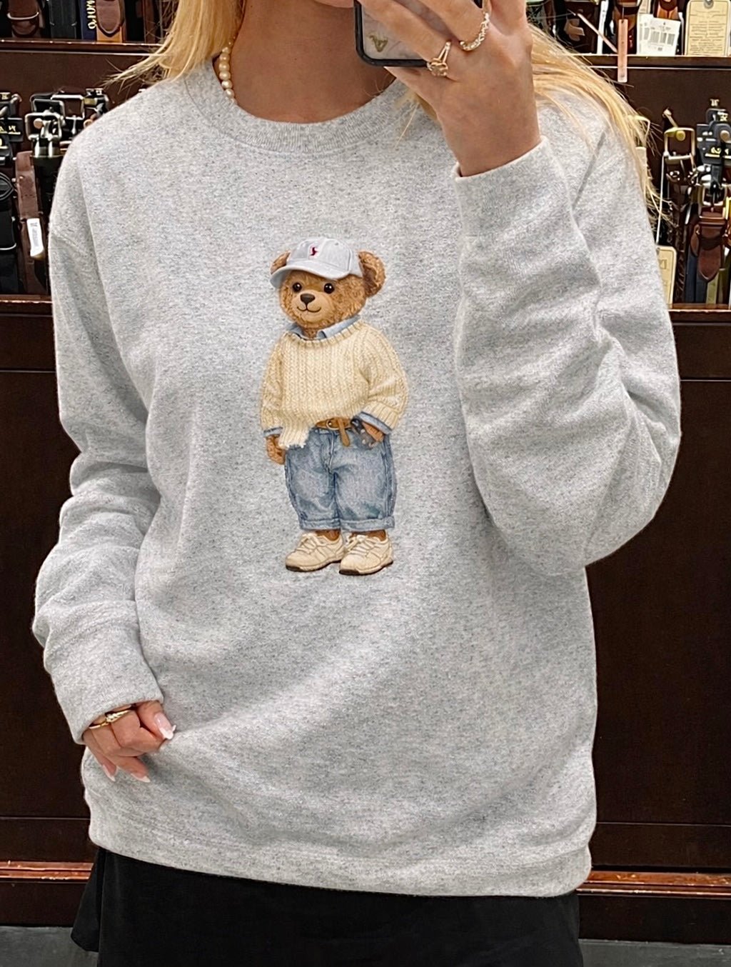 Light gray crewneck sweatshirt, teddy bear graphic in knit sweater and denim overalls