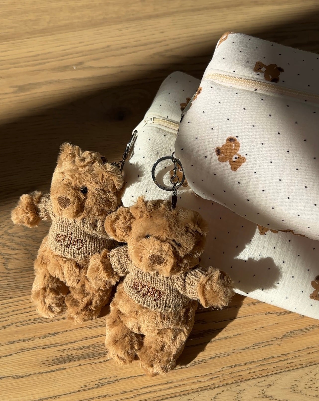 Tan plush bear keychain with metal ring and knit sweater detail